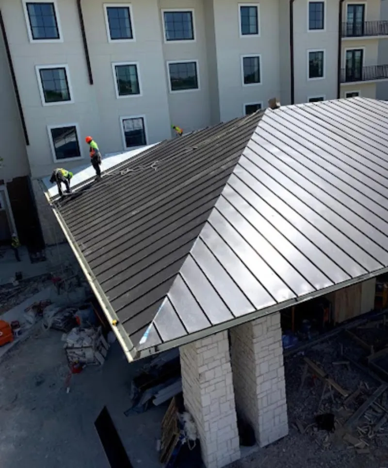 Crew installing standing seam metal roof panels on a commercial project in Windsor Locks